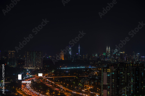 Night view of Kuala Lumpur city with busy traffic jam on the highway. 