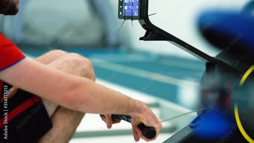 Professional athlete rower training on rowing machine. Young