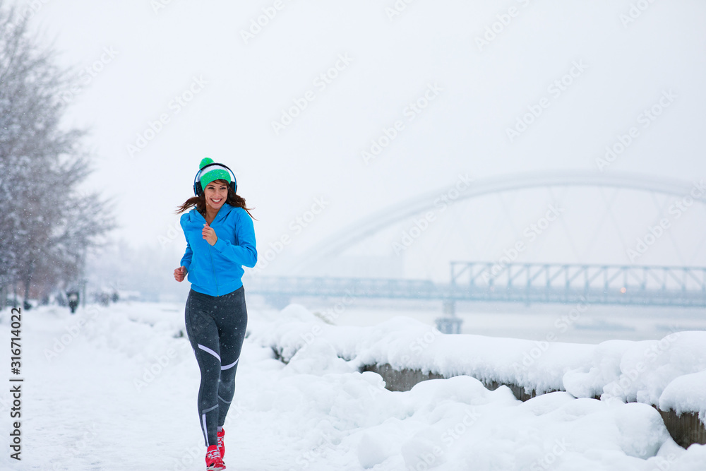 Young woman jogging on a snowy day