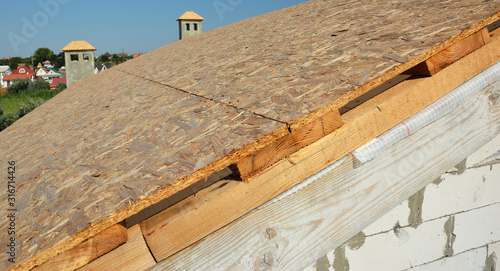 Roofing construction house roof with covering oriented strand boards  OSB  before asphalt shingles installation.