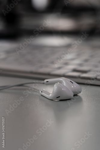 Kopfhörer mit Kabel liegend vor Tastatur aus Aluminuim photo