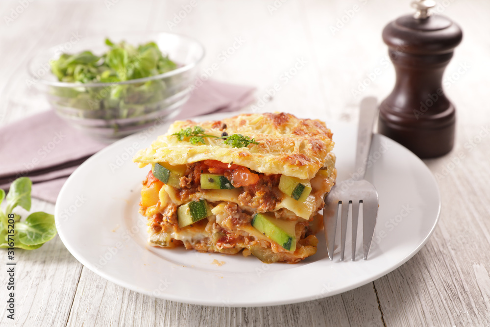 plate of lasagna with minced beef, tomato sauce and vegetable plate of lasagna with minced beef, tomato sauce and vegetable
