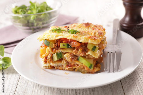 plate of lasagna with minced beef, tomato sauce and vegetable