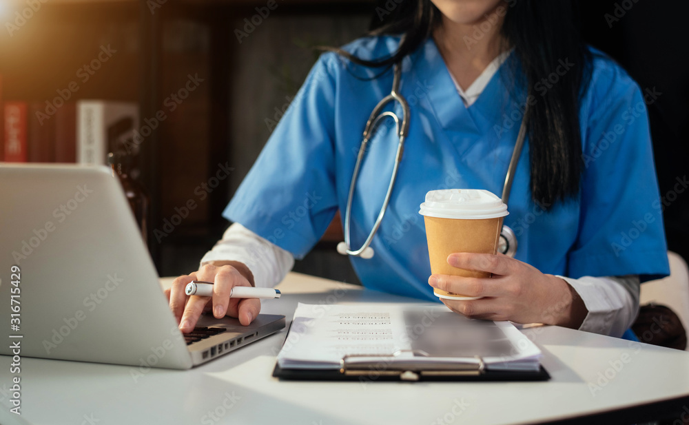 Female doctor working on desk with laptop computer and paperwork in the office. Medical and doctor concept. Female doctor working on desk with laptop computer and paperwork in the office. Medical and doctor concept.