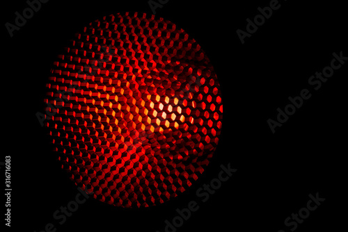 Closeup honeycomb grid texture with red light. Red and dark metal hexagon shaped pattern abstract background. Light modifier equipment. Metal honeycomb. Futuristic pattern. Honey grid cells network.