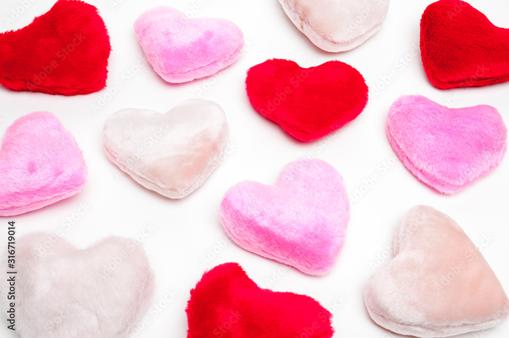 Fluffy little pink and red plush hearts sitting in a romantic group on white background