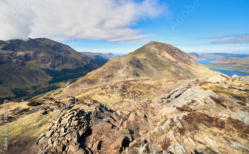 Принти на полотні Summits of Pillar on the left with Ennerdale valley, forest with the summits of Seat and High Crag in the centre and Buttermere on the righ in the English Lake District on a sunny day