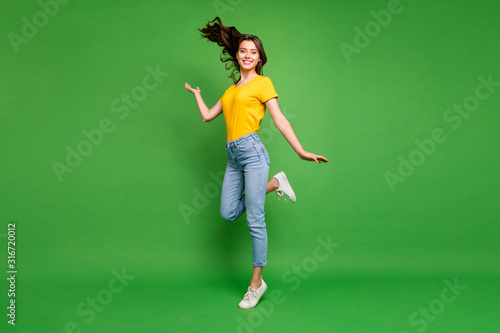 Full length body size view of her she nice attractive lovely cheerful cheery wavy-haired girl standing on tiptoe having fun free time isolated over bright vivid shine vibrant green color background photo
