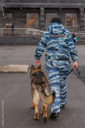 Female police officers with a trained dog. German shepherd police dog. Russian Police. Sign means "Police" in Russian.