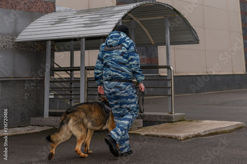 Female police officers with a trained dog. German shepherd police dog. Russian Police. Sign means 