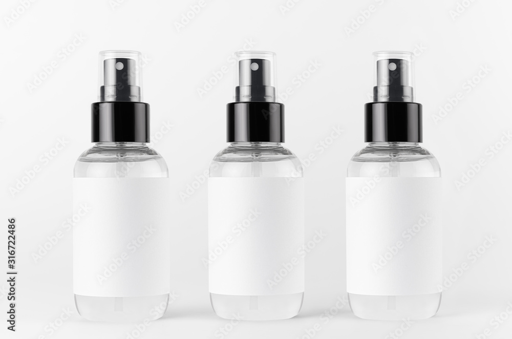 Three transparent spray bottles for cosmetics product with white blank label on white background, mock up for branding, advertising, presentation, design. Three transparent spray bottles for cosmetics product with white blank label on white background, mock up for branding, advertising, presentation, design.
