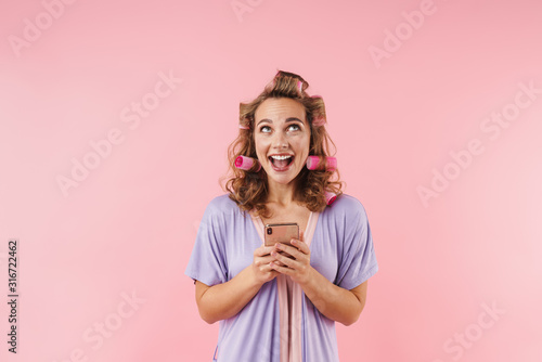 Image of young happy woman smiling and using cellphone