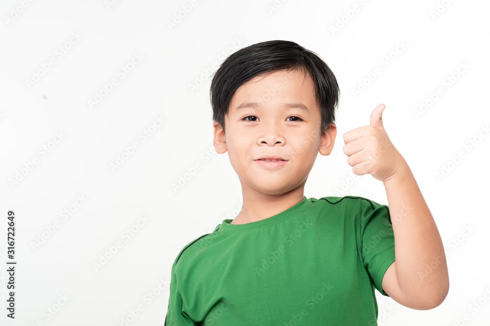 Smiling boy in white t-shirt showing thumb up on a light background Smiling boy in white t-shirt showing thumb up on a light background