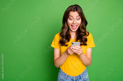 Portrait of her she nice attractive lovely charming girlish cheerful cheery wavy-haired girl having fun using app 5g device isolated over bright vivid shine vibrant green color background