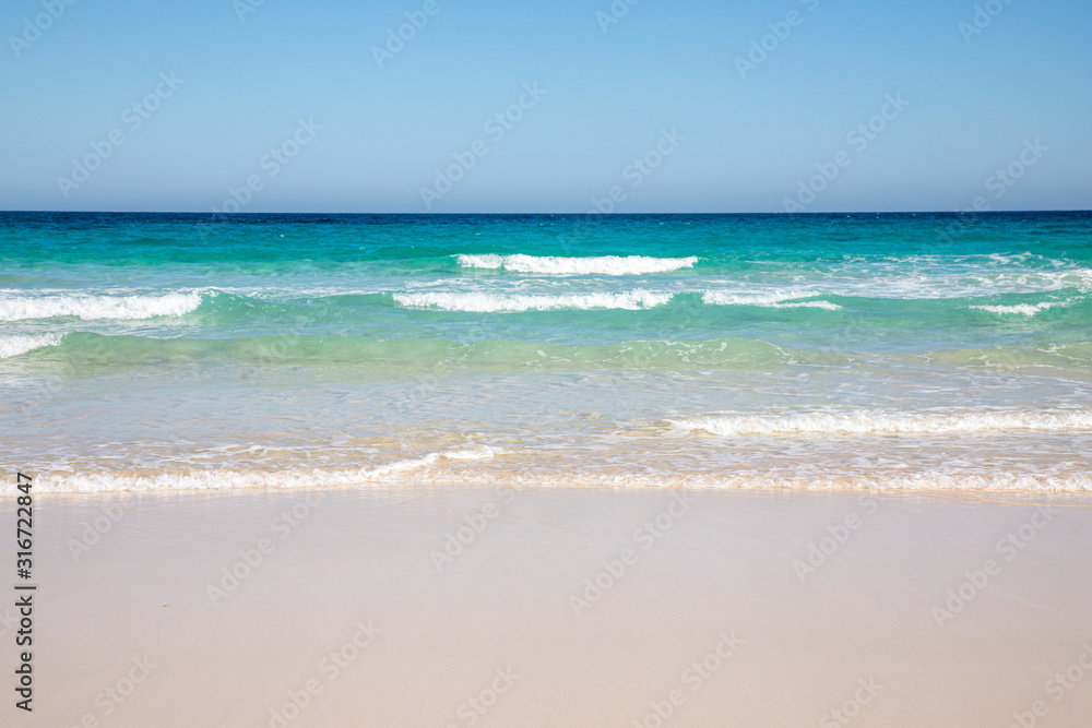 Cloudless sky over a colorful sea with diferent colors aquamarine turquoise dakr blue azure with waves prducing white foam crushing against a yellow beach summer sumertime sunny calm water tranquil Cloudless sky over a colorful sea with diferent colors aquamarine turquoise dakr blue azure with waves prducing white foam crushing against a yellow beach summer sumertime sunny calm water tranquil