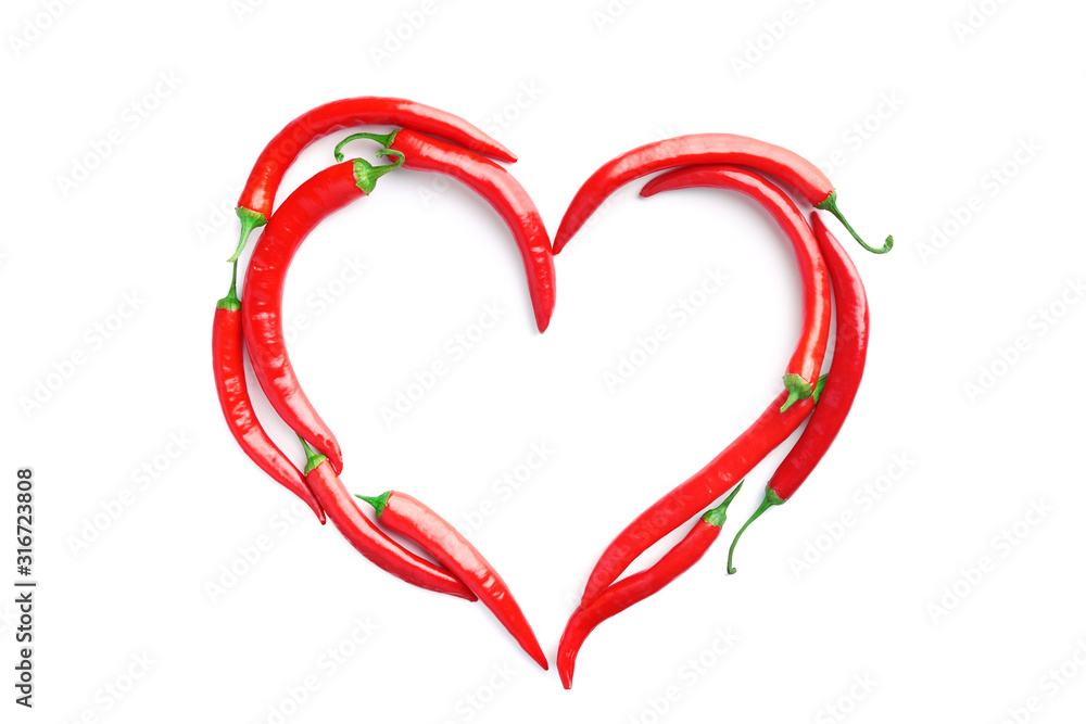 Red chilli peppers laid out in form of heart on white background. Concept of passion, addiction to spicy food, Valentines day