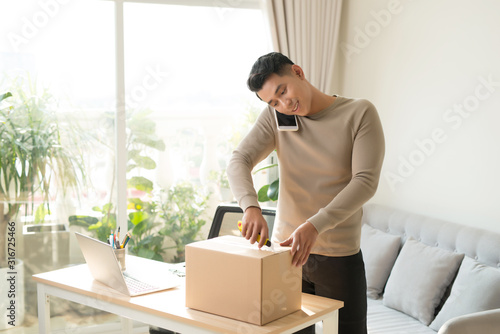 Man opening fragile parcel ordered from internet photo