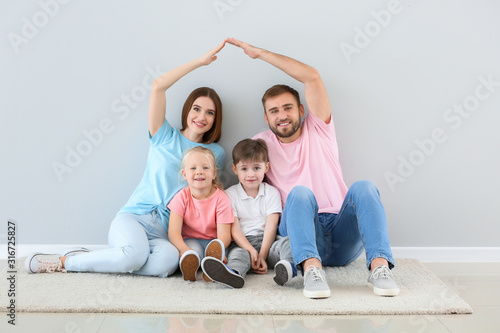 Portrait of happy family near light wall