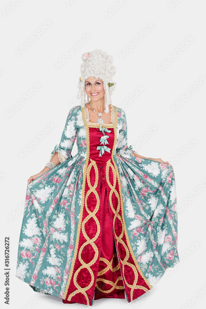 Portrait of happy senior queen standing over gray background