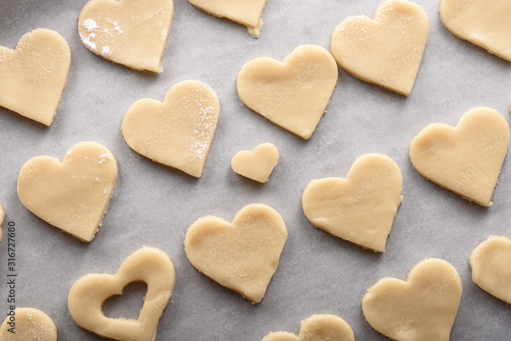 uncooked cookies hearts on parchment paper