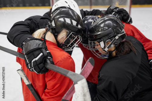Photography High angle portrait of female hockey team huddling for motivation before sports