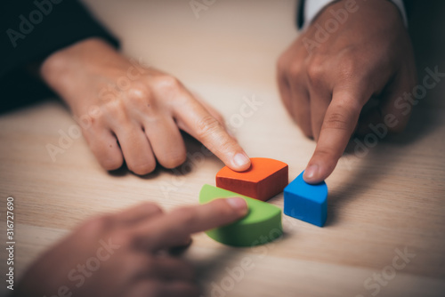 businessman hand placing the last jigsaw puzzle piece, Hand holding missing jigsaw puzzle piece down in to the place, conceptual of problem solving, finding a solution.