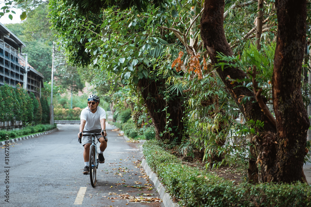 Asian young man ride road bikes on the road in the morning Asian young man ride road bikes on the road in the morning