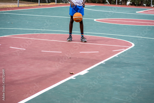 Young boy practicing his free throws on court © rushay