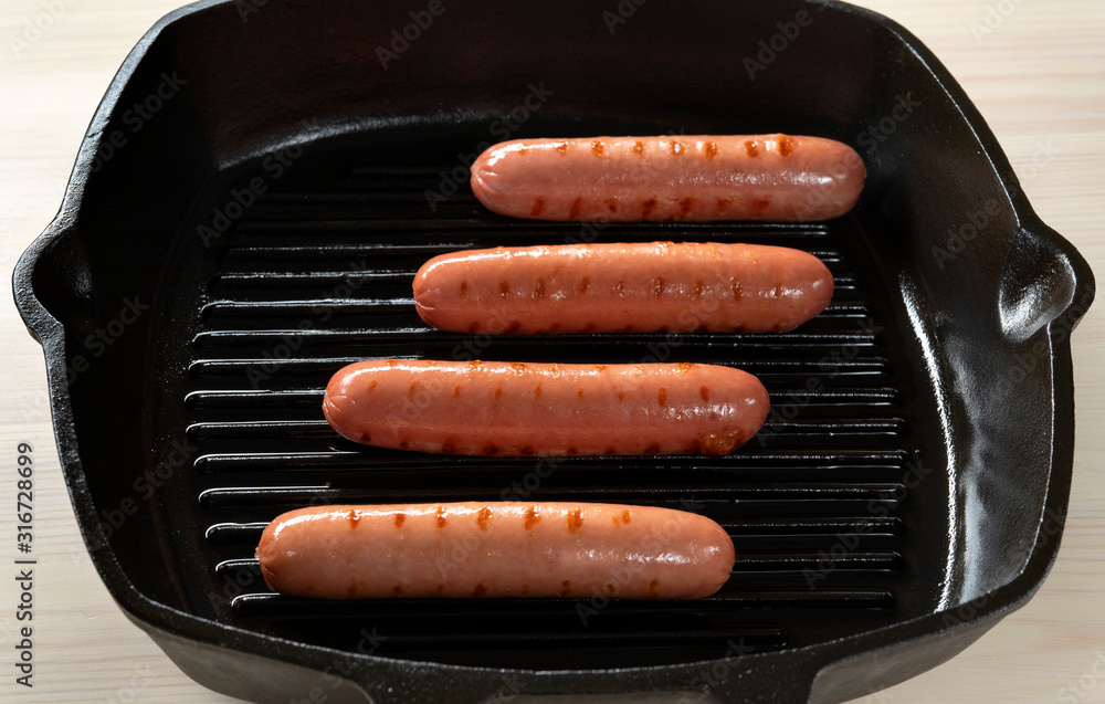 Fried sausages on a frying cast-iron pan, Front view. Fried sausages on a frying cast-iron pan, Front view.
