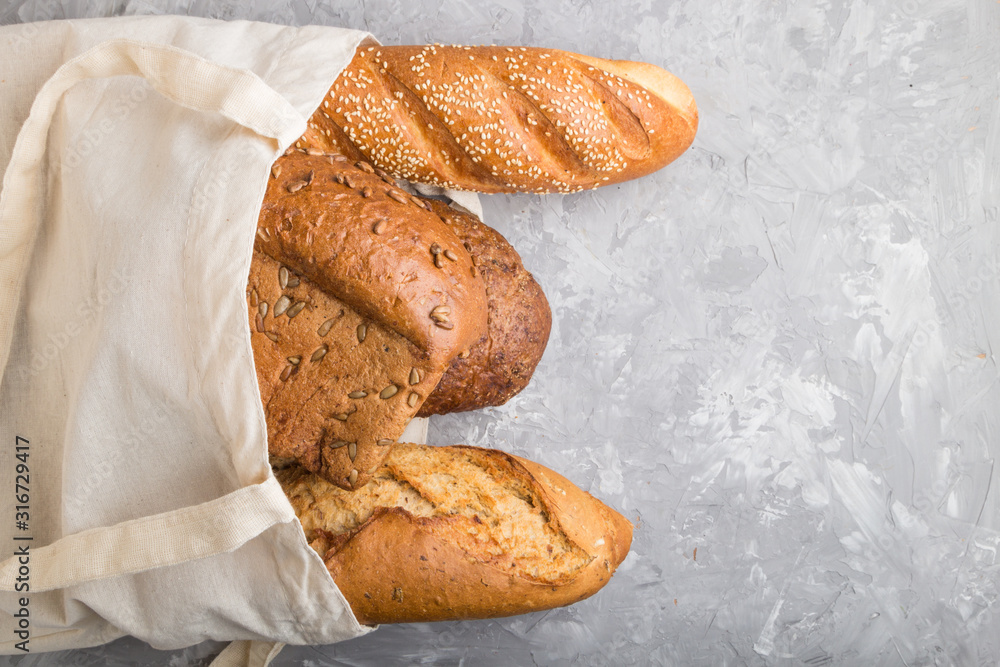 Reusable grocery bag with fresh baked bread on a gray concrete background. top view, copy space. Reusable grocery bag with fresh baked bread on a gray concrete background. top view, copy space.
