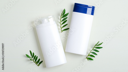 Wallpaper Mural White plastic bottles branding mockup used for shampoo, lotion, shower gel and green leaves. Cosmetics SPA packaging, minimalist flat lay style Torontodigital.ca