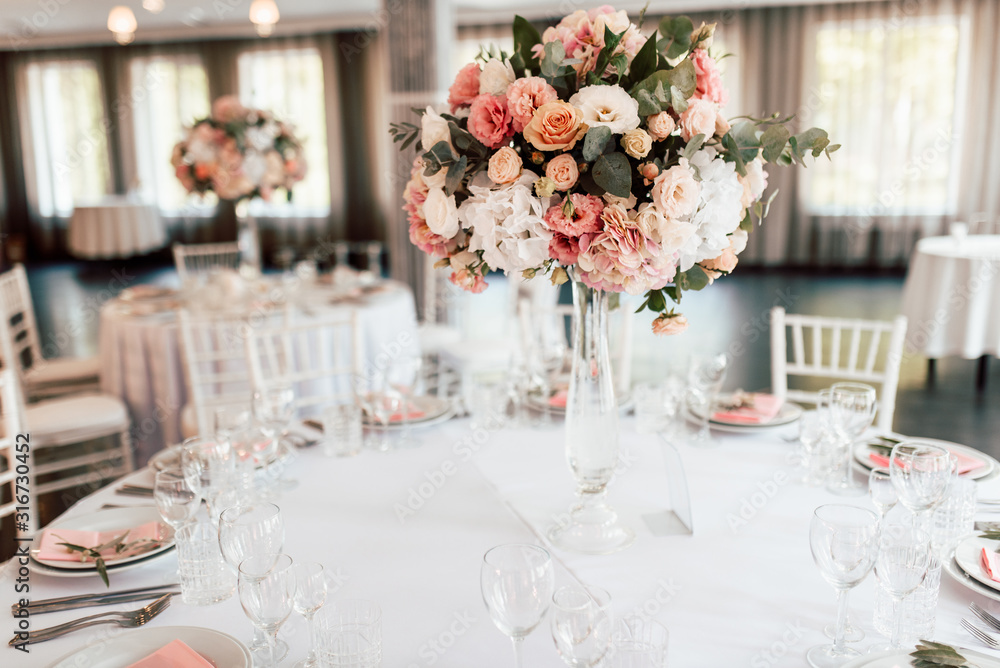 Festive table setting with a floral arrangement in the center and with a table number Festive table setting with a floral arrangement in the center and with a table number