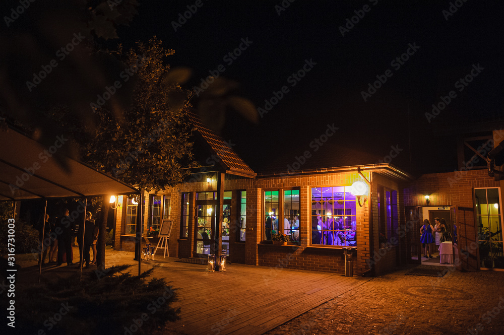 View of restaurants from outside at night. Wedding party