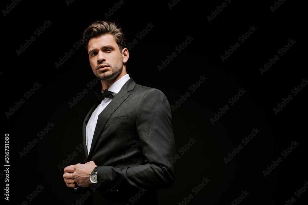elegant man in suit looking at camera isolated on black elegant man in suit looking at camera isolated on black