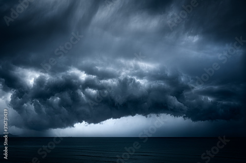 Fototapeta dark and dramatic stormy clouds over sea