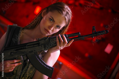 Beautiful girl with guns in hands in a gun shop.