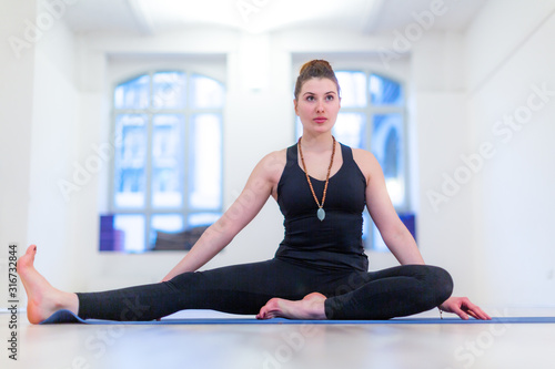 Young woman seated side stretch practicing yoga position
