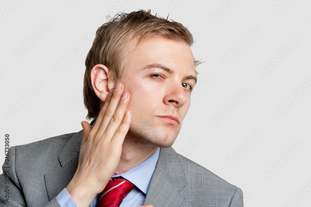 Portrait of businessman with hand on chick looking sideways over colored background Portrait of businessman with hand on chick looking sideways over colored background