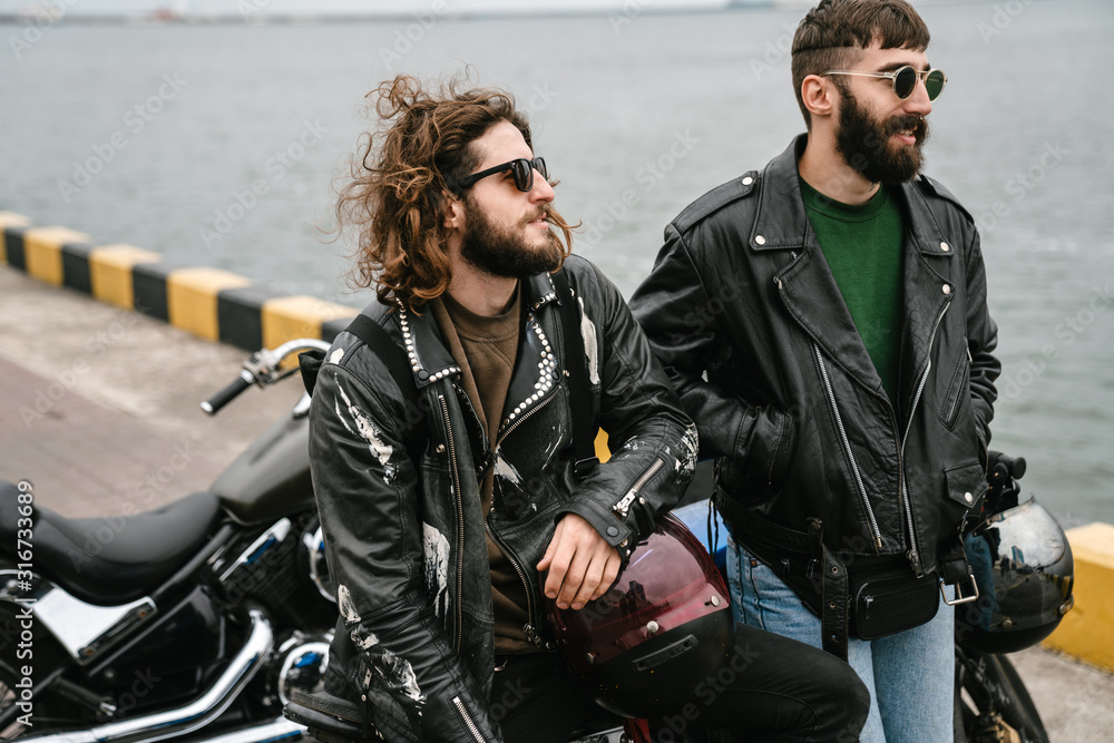 Photo of bearded caucasian men bikers talking while standing