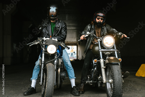 Photo of bearded brutal men bikers on bikes wearing helmets photo