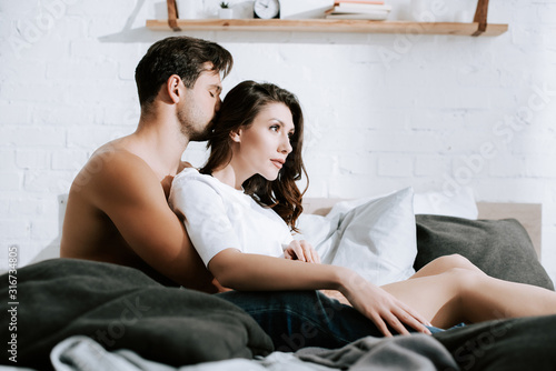 Konstfotografi selective focus of man kissing head of attractive girl at home