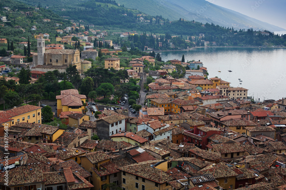 Panorama of one of the most beautiful cities on lake Garda in the province of Veneto in Northern Italy - Malcesine, view over the rooftops, Scaliger castle and Lago di Garda