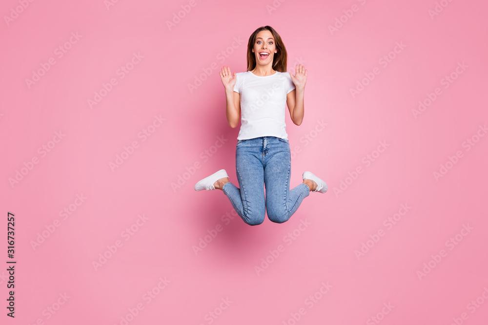 Photo of beautiful crazy lady jumping high enjoy summer sunny weekend days playful mood wear casual white t-shirt jeans sneakers isolated pink color background Photo of beautiful crazy lady jumping high enjoy summer sunny weekend days playful mood wear casual white t-shirt jeans sneakers isolated pink color background