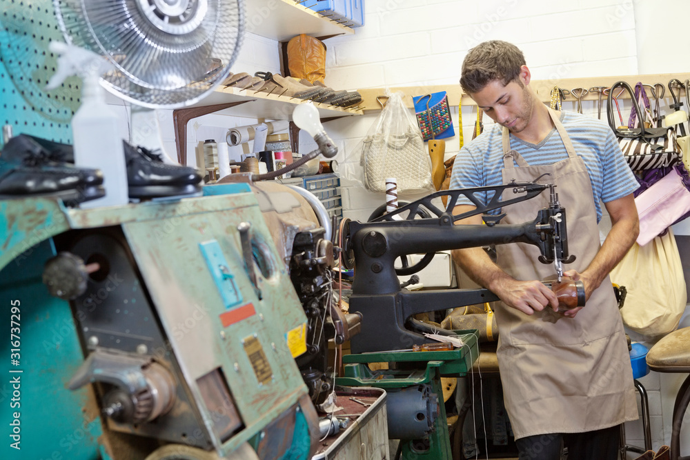 Young shoemaker concentrating on work Young shoemaker concentrating on work