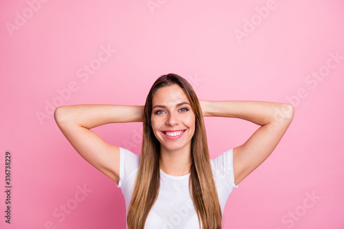 Closeup photo of beautiful pretty lady peaceful harmonic mood holding arms behind head toothy dreamy smiling wear casual white t-shirt isolated pink color background