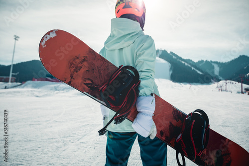 Vászonkép One young woman snowboarding in winter mountains