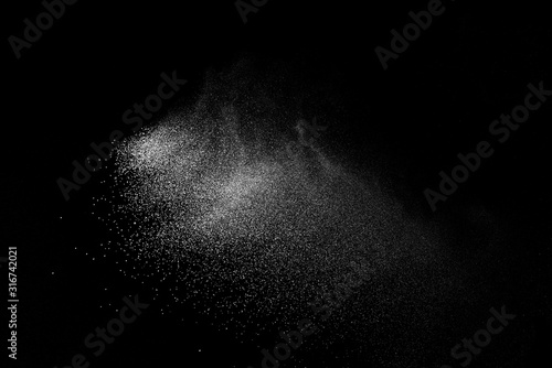 Freeze motion of white color powder exploding on dark background. 