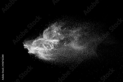 Freeze motion of white color powder exploding on dark background. 