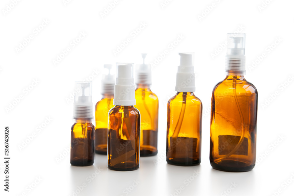 Group of empty glass spray bottles over white background