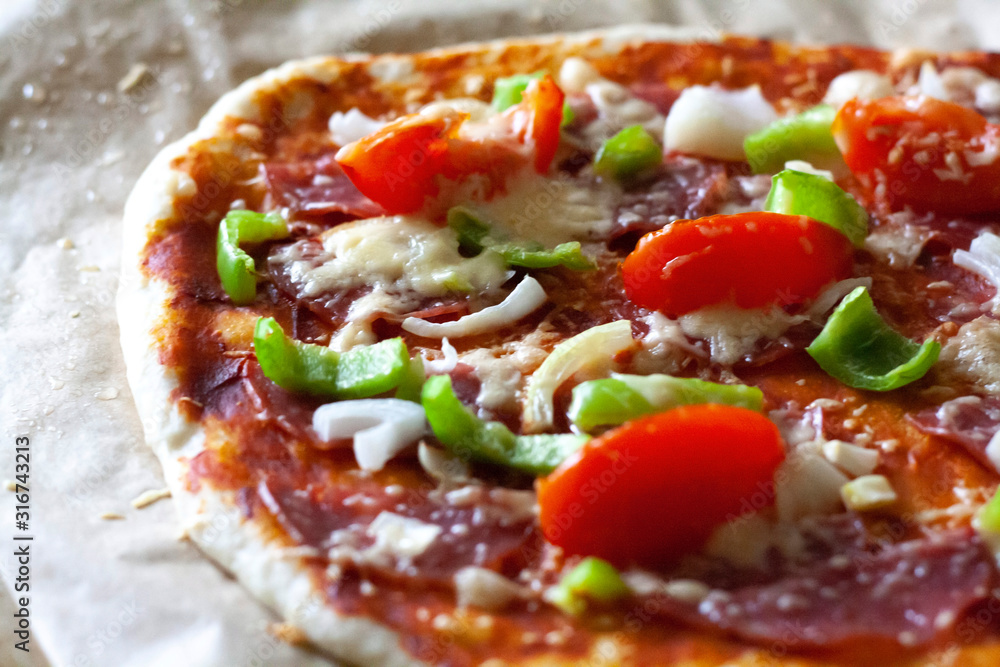Homemade pizza with tomatoes, onions, salami and sweet peppers Homemade pizza with tomatoes, onions, salami and sweet peppers